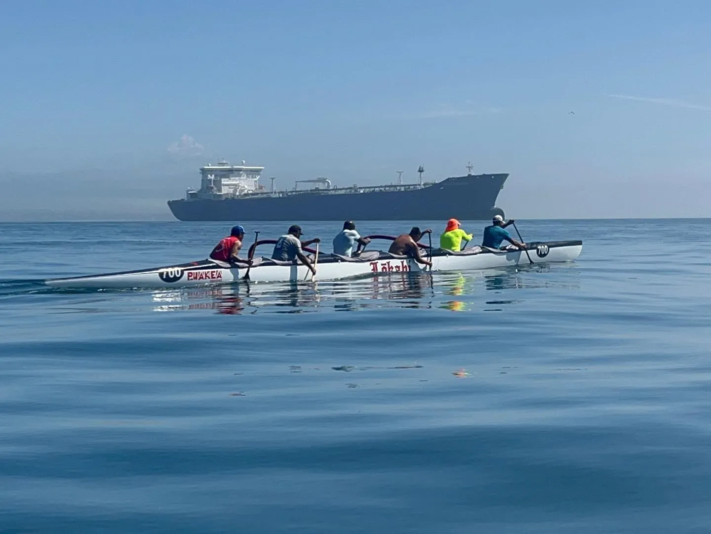 Lokahi paddling near cargo ship